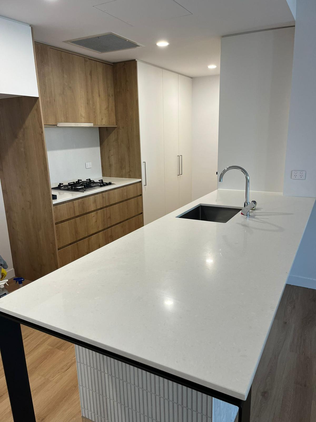 Clean modern kitchen with timber cabinetry and quartz island benchtop
